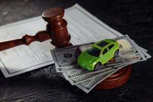 Toy car on dollar banknotes and wooden judge gavel