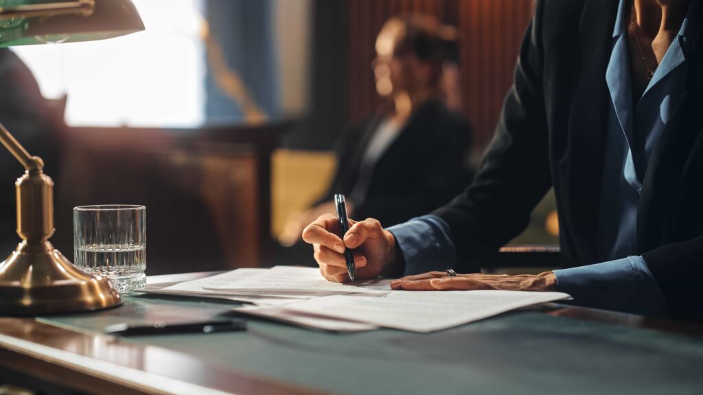 Lawyer reviewing legal documents at courtroom desk during trial proceedings