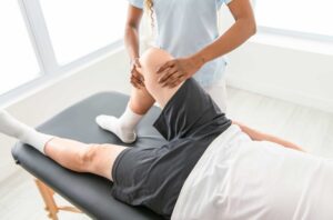 Physical therapist helping patient with knee rehabilitation after injury