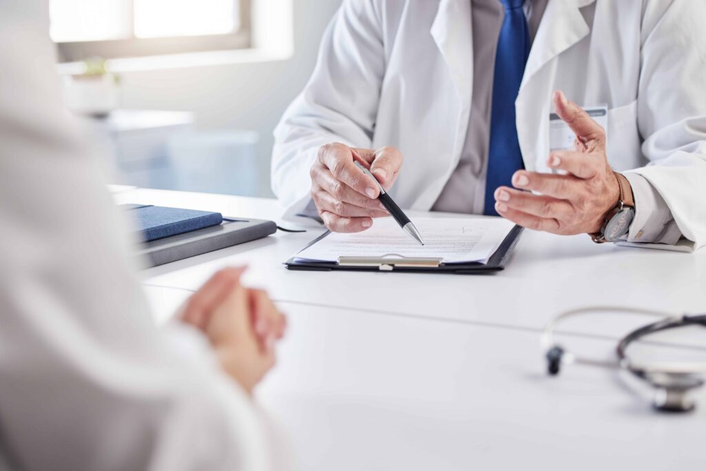 Doctor discussing medical report with patient during consultation at hospital office. Doctor discussing medical report with patient during consultation at hospital office.