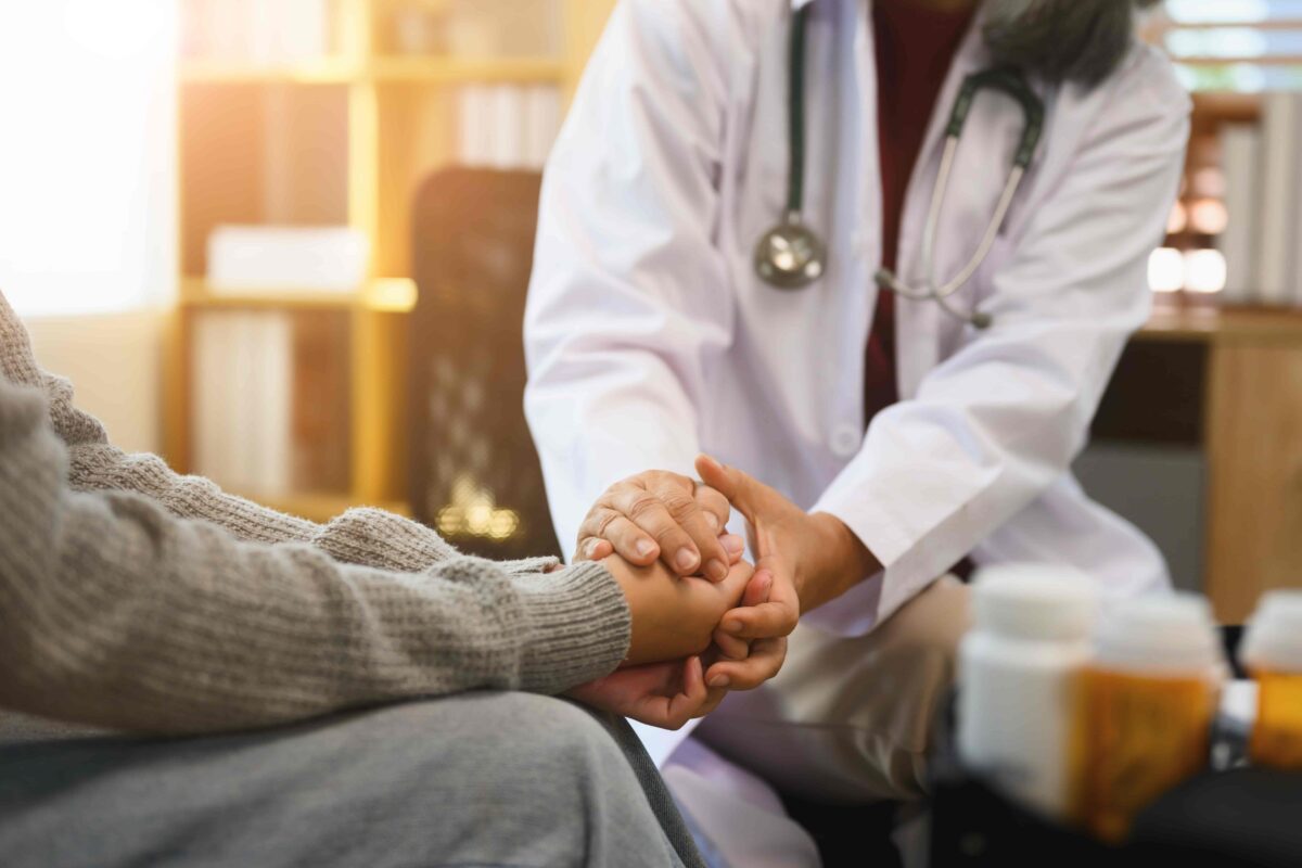 Doctor comforting patient with supportive hand during medical consultation