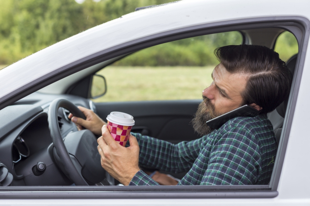 man distracted while driving a car